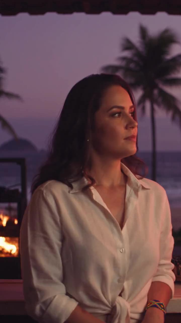 Mariana at her beach kiosk in Ipanema, the charcoal glow rising behind her
